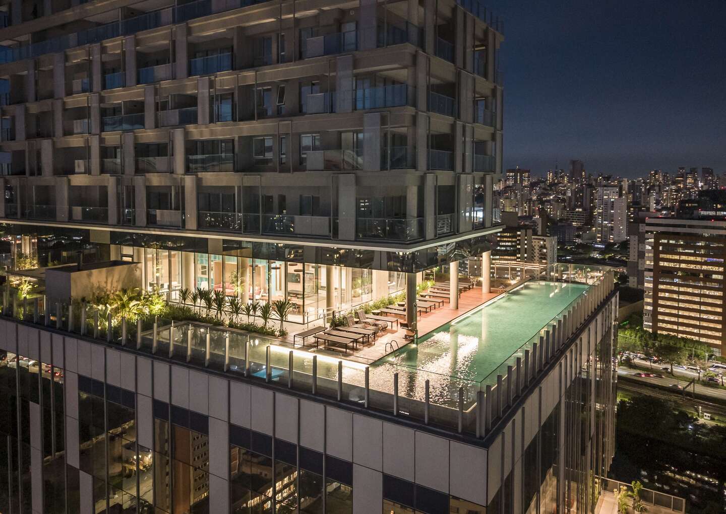 Piscina com vista noturna do River South Residences, foto real